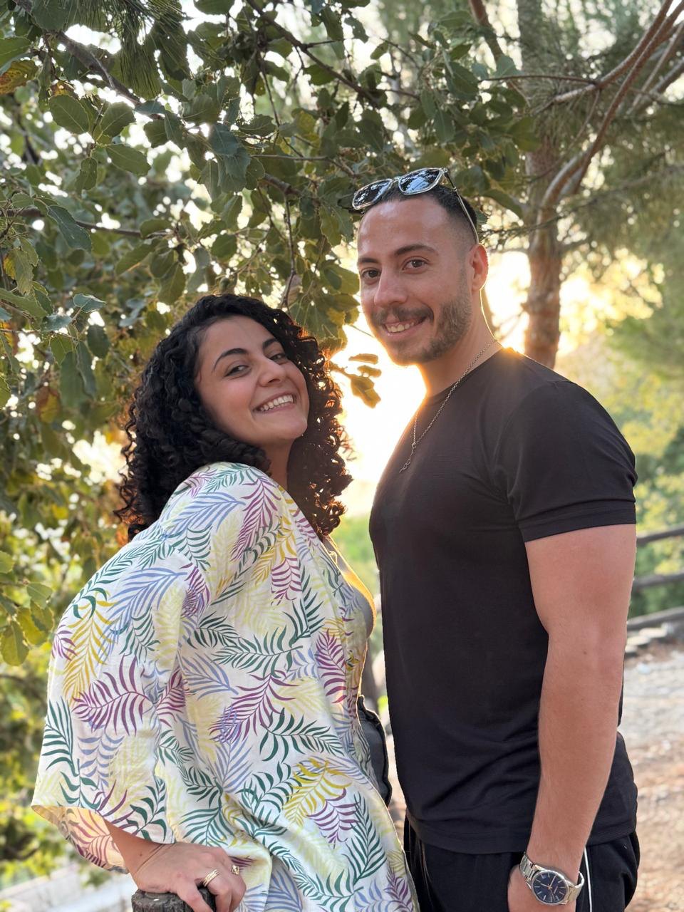 The couple together at golden hour under the pines